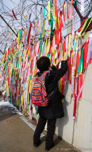 South Korea woman pins a message on the fence at the DMZ. There is no contact for families divided between South and North Korea Photo: Angela Neal Grove