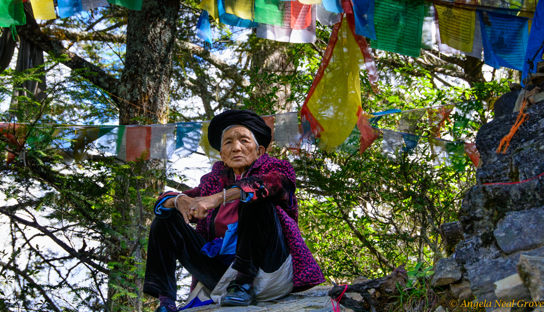 Tibetan womabn waiting on mountain-top pilgrimage route