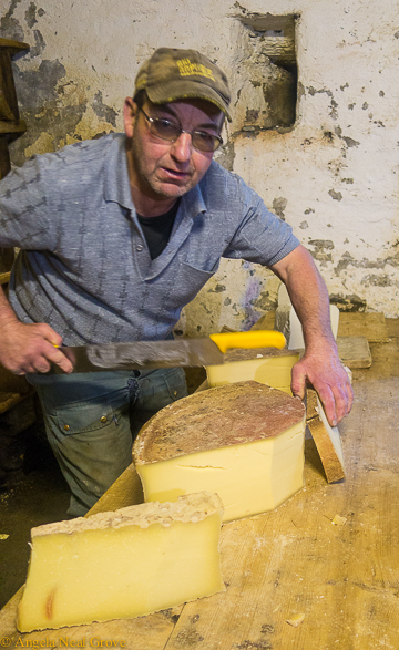 Mont Blanc challenge: cutting thick slices of world famous Beaufort cheese for a picnic lunch