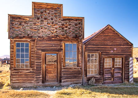 Is Bodie Ghost Town Haunted? On the left is Sam Leon's bar.  He was owner of the U.S. Hotel until it was destroyed inthe 1932 fire.  After 1937 he operated a bar here. On the right is a barber shop. Looking through the windows barbers chairs and wash basins can be seen.PHOTO://ANGROVE