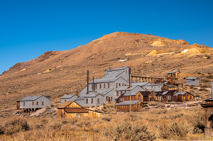 Is Bodie Ghost Town Haunted? The old stamp mill and mineworkings at the back of the town of Bodie. On the hillside can be seen piles of tailings from the gold processing.
  Photos://ANGROVE