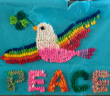 Symbol of peace with dove and rainbows in origami cranes.  Cranes are a symbol of peace in Japan. This was made by children of Nagasaki. It is in the Bomb Museum. PHOTO//ANGROVE