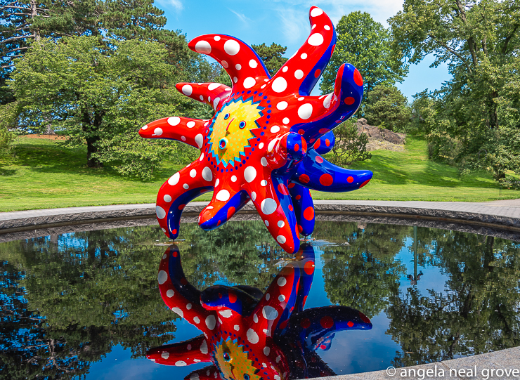 Enchanting Pumpkins:I Want to Fly to the Universe, 2020 seems to dance about the reflecting pool.  Situated near the entrance, it immediately capitvates visitors, drawing them into Kusama's world. PHOTO; ANGROVE