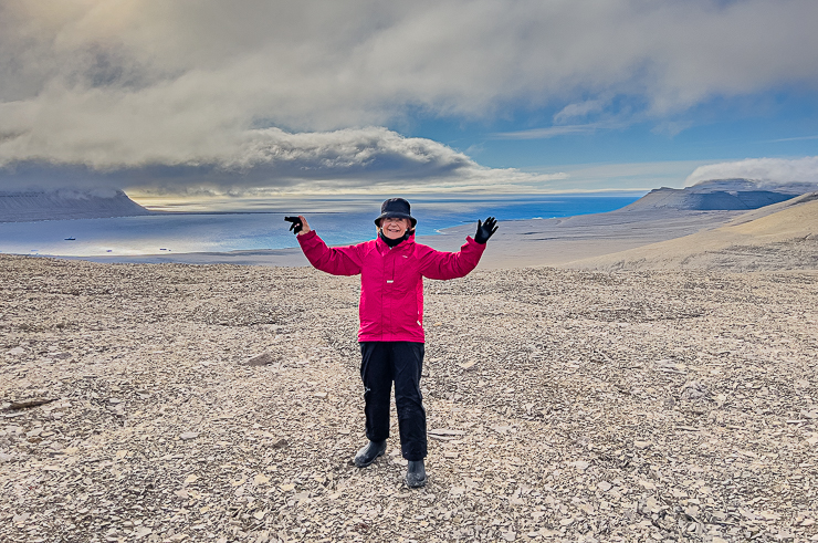 Northwest Passage Arctic Adventure: Devon Island: On top of the world!  Hiking on rocky shale is challenging, especially in muck boots needed to cope with soggy tundra near the shore and wet landings from zodiac inflatable boats. In the distant left is Asteria yacht.  It was quite a climb!
