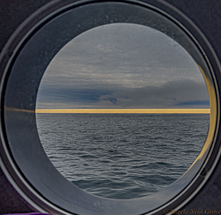 Northwest Passage Arctic Adventure: Storm coming. Near Devon Island with a forecast of a storm.The weather system is taking up most of the sky.  Seen from my porthole.//PHOTO:ANGROVE