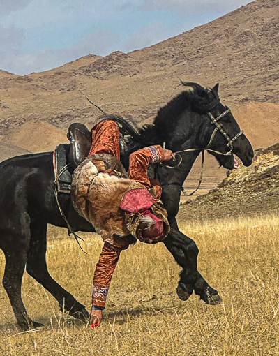 Tenge ilu, traditional Kazakh game picking up coins while galloping at speed